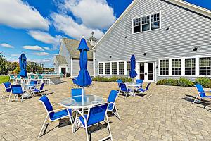 een patio met blauwe stoelen, tafels en parasols bij The Salty Starfish in Arundel