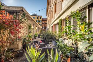an alley with plants and tables and buildings at AwesHomeItaly - Hanging Gardens in Pisa