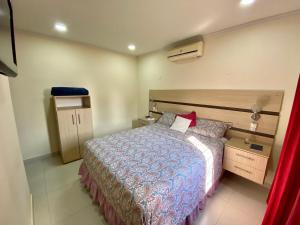 a bedroom with a bed with a blue comforter at Agradable casa independiente con jardín y estacionamiento in Ciudad del Este