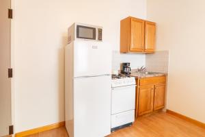 a kitchen with a white refrigerator and a microwave at West 30th Street Guest House in New York