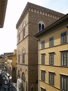 un edificio alto de ladrillo en una ciudad con una calle en Residenza Della Signoria, en Florencia