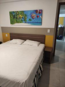 un lit dans une chambre avec un tableau sur le mur dans l'établissement Apartamento em Olímpia, à Olímpia
