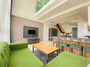 a living room with a green couch and a table at Luna Mare Resort Mersin in Mersin