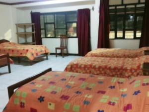 1 dormitorio con 2 camas, mesa y sillas en Hostal Valle Hermoso, en Tupiza