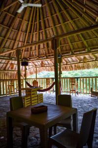 a wooden table and chairs in a thatch hut at Cabaña Ecoturistica Mirador del Bosque Tayrona in Calabazo