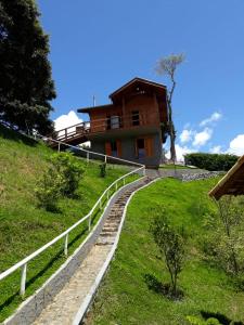 ein Haus an der Seite eines Hügels mit einem Zaun in der Unterkunft Chalé Recanto Lobo Guará in Gonçalves