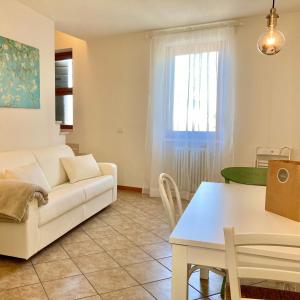 a living room with a white couch and a table at Corte Mantovani - Appartamenti in Colà di Lazise