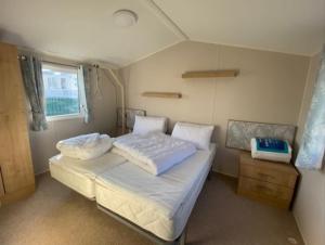 a small bedroom with two beds and a window at Emma's Escape accessible caravan at Durdle Door in West Lulworth