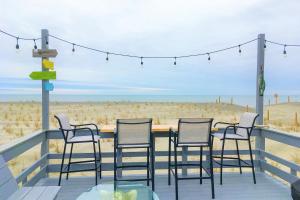 d'une terrasse avec des chaises et une table et la plage. dans l'établissement The Ocean Rose, à Île au chêne