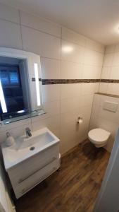 ein Badezimmer mit einem weißen Waschbecken und einem WC in der Unterkunft MF Manuele Ficano - Ferienwohnungen am Bodensee - Fewo Stella in Kressbronn am Bodensee