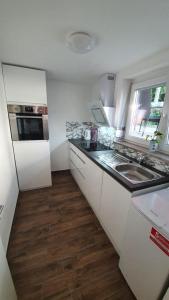 a white kitchen with a sink and a refrigerator at MF Manuele Ficano - Ferienwohnungen am Bodensee - Fewo Stella in Kressbronn am Bodensee