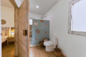 
a small bathroom with a toilet and a sink at Sonora Jungle & Yoga Retreat in Puerto Viejo
