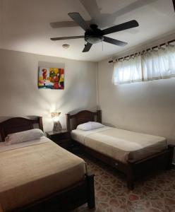 a bedroom with two beds and a ceiling fan at Stone Cabins Boquete in Boquete