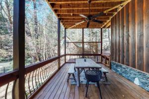 eine Holzterrasse mit einem Tisch und Stühlen darauf in der Unterkunft Le Hermitage in Ellijay