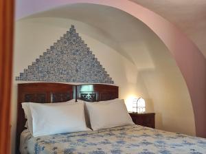 1 dormitorio con 1 cama con colcha azul y blanca en MY CHARMING HOUSE - Luna apartment, en Ravello