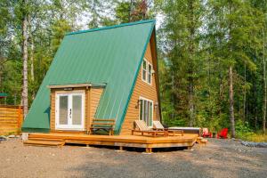 une petite maison avec un toit vert dans les bois dans l'établissement A-Frame of Mind, à Rhododendron