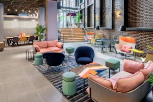 eine Lobby mit Sofas, Tischen und Stühlen in der Unterkunft YOTEL London City in London