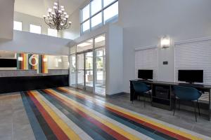 a lobby with a desk with two monitors and chairs at Studio 6 Pensacola, FL - West I-10 in Pensacola