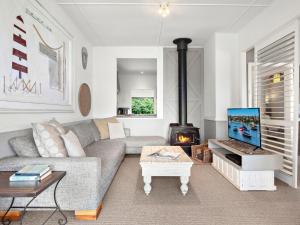 un salon avec un canapé et une cheminée dans l'établissement The Beach House Gerroa, à Gerroa