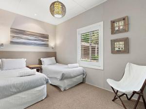 une chambre avec deux lits et une fenêtre dans l'établissement The Beach House Gerroa, à Gerroa
