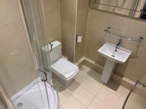 een badkamer met een douche, een toilet en een wastafel bij Entire Seaside Home, Sleeps 8, All en-suite rooms in New Brighton