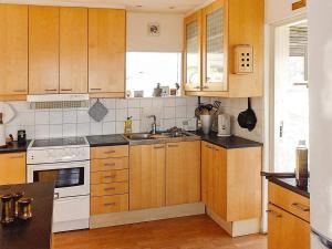 a kitchen with wooden cabinets and a white stove top oven at 4 person holiday home in VEBER D in Veberöd