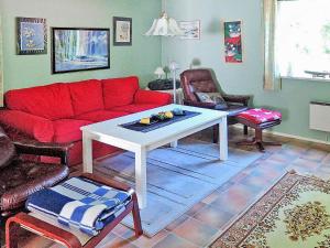 - un salon avec un canapé rouge et une table dans l'établissement 6 person holiday home in H STVEDA, à Hästveda