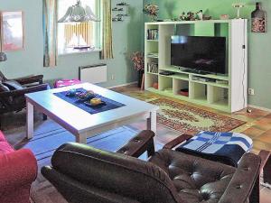 - un salon avec une table et une télévision dans l'établissement 6 person holiday home in H STVEDA, à Hästveda