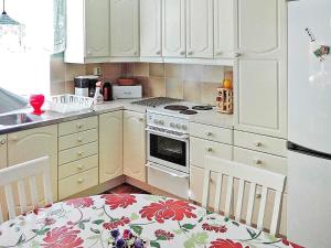 - une cuisine avec des placards blancs et une cuisinière dans l'établissement 6 person holiday home in H STVEDA, à Hästveda