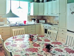 - une cuisine avec une table et un tissu de table à fleurs dans l'établissement 6 person holiday home in H STVEDA, à Hästveda