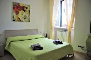 1 dormitorio con 1 cama verde y 2 toallas en Apartment in Lurago Derba - Como Provinz 42304, en Lurago D'Erba 