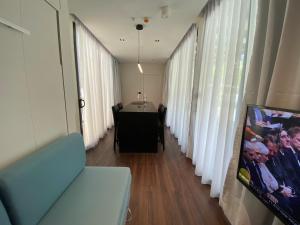 a room with a table and a room with windows at Shipping Container Hotel At One-north in Singapore