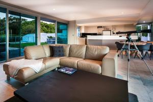una sala de estar con un sofá y una mesa en Horizons House - spacious, ocean + bush views, peaceful, en Margaret River Town
