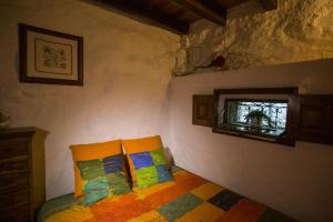 a bedroom with a bed with two pillows and a window at Casa de Ribô in Soajo
