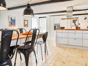 een keuken met een houten tafel en zwarte stoelen bij 5 person holiday home in Aakirkeby in Åkirkeby