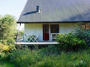 ein kleines Haus mit einem Tisch und einer roten Tür in der Unterkunft 7 person holiday home in DJURHAMN in Djurhamn