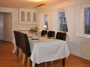 mesa de comedor con sillas y mantel blanco en 6 person holiday home in MELLERUD, en Mellerud