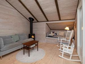 een woonkamer met een bank, een tafel en een fornuis bij 4 person holiday home in V ggerl se in Bøtø By