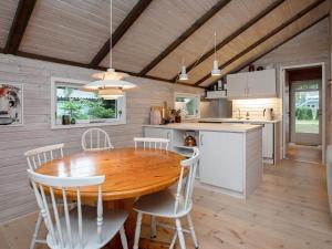 een keuken en eetkamer met een houten tafel en stoelen bij 4 person holiday home in V ggerl se in Bøtø By