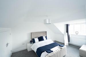 a white bedroom with a bed and a couch at Entire Modern Home with Private Parking for 6/8 Persons in Worksop
