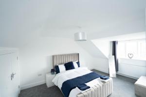 een witte slaapkamer met een bed en een bank bij Entire Modern Home with Private Parking for 6/8 Persons in Worksop