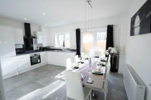 una cucina e una sala da pranzo con tavolo e sedie di Entire Modern Home with Private Parking for 6/8 Persons a Worksop