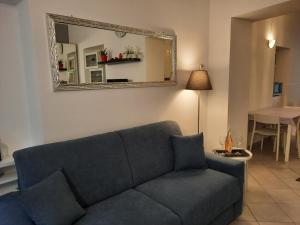 sala de estar con sofá azul y espejo en La Perla sul Lago di Como con parcheggio, en Como