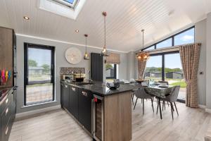 a kitchen with a large island with a counter top at Ael-Y-Bryn - Luxury Lodge, Hot Tub, Three En-Suite Bedrooms in Penally