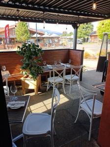 una mesa con sillas y copas de vino en un patio en Snowman Lodge and Spa, en Ohakune