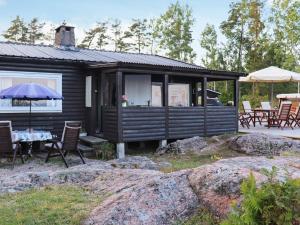 eine Hütte mit einem Tisch, Stühlen und einem Sonnenschirm in der Unterkunft Holiday home FRÄNDEFORS V in Frändefors