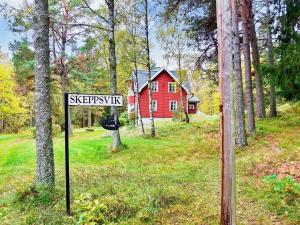 a street sign in front of a red house at 5 person holiday home in NORRT LJE in Nävekvarn