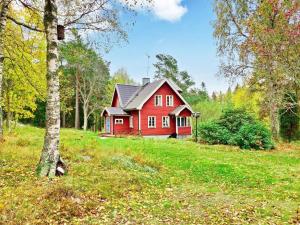 a red house in the middle of a field at 5 person holiday home in NORRT LJE in Nävekvarn