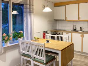 4 person holiday home in KRISTIANSTAD في كريستيانستاد: مطبخ مع طاولة خشبية وأربع كراسي