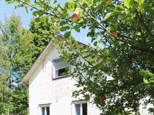 a white house with a tree in front of it at 6 person holiday home in STRA NTERVIK in Östra Ämtervik